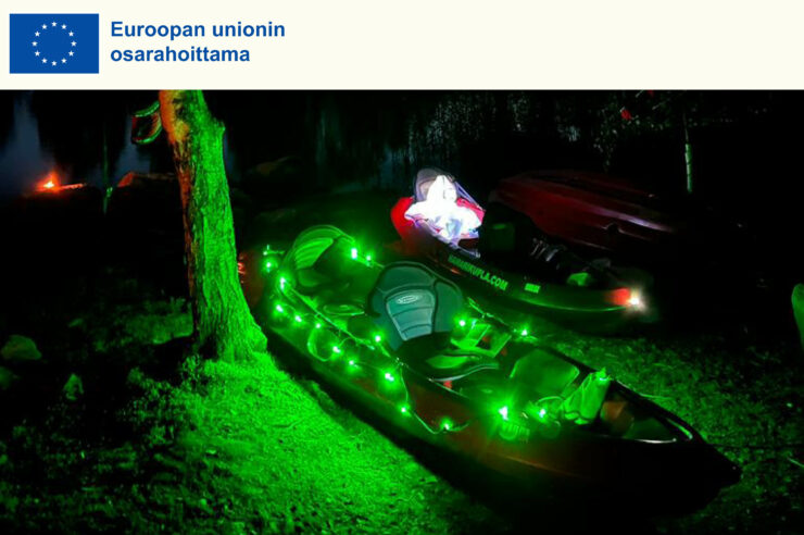 Euroopan unioni osarahoittama. Kuvassa ledivaloin valaistut kanootit loistavat pimeässä rannassa.